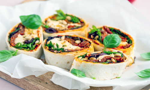 Mediterranean Wrap Plate sliced diagonally on a clean wooden board